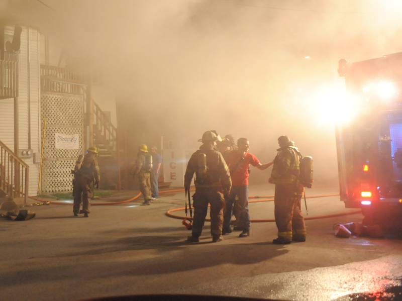 Utica fire chief Ben Brown (red) directs firefighters as they arrive on the scene to fight a fire above Skoogs Pub & Grill on Sunday, May 10, 2015 downtown Utica.