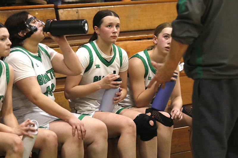 Alden-Hebron's Martha Aguilar, (from left to right) Hayden Smith and MacKenzie Maule listen to coach Martin Hammond during a nononference girls basketball game against Woodlands Academy on Thursday, Jan. 29, 2026, at Alden-Hebron High School in Hebron.