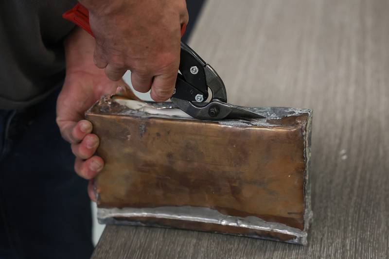 Randy Williams cuts open a time capsule at Grompers Junior High School on Wednesday, May 1, 2026 in Joliet. In 1969 students placed items in a time capsule and sealed it inside a wall when an extension was built at Grompers Junior High School.