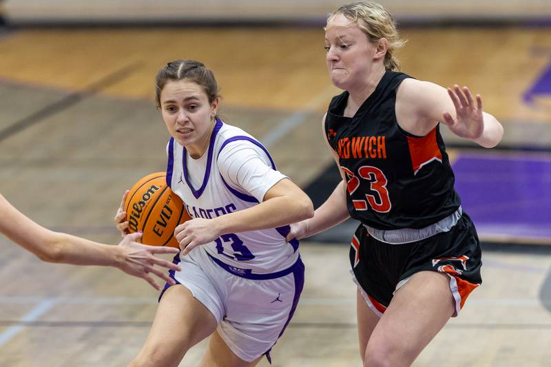 Plano's Josie Larson (white jersey, 23) drives past the defense of Sandwich's Bailey Frieders during Tuesday's game in Plano.