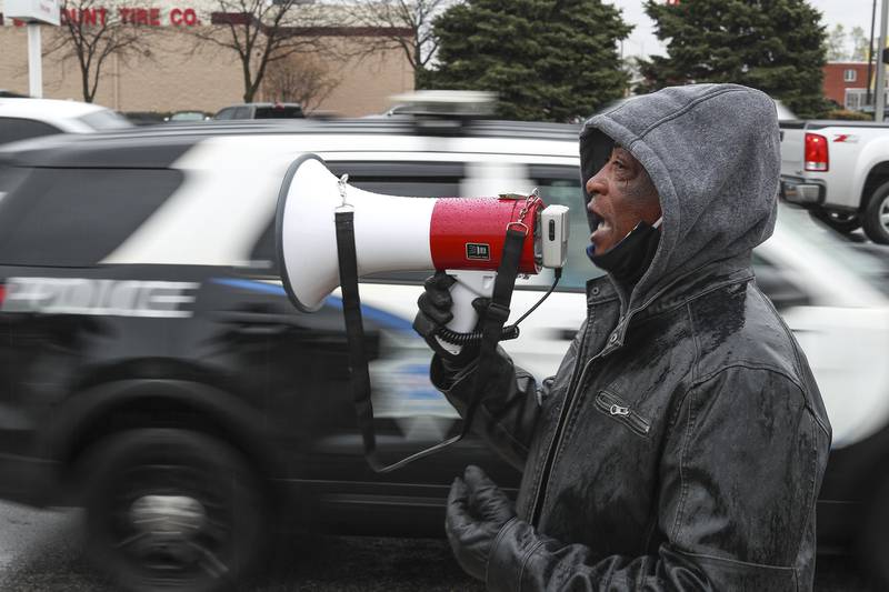 Rev. Larry Ellis of St Mark CME Church calls for justice for George Floyd as a Joliet Police Department squad car drives past on Monday, April 19, 2021, at the intersection of Jefferson St. and Larkin Ave. in Joliet, Ill. Members of Joliet's community of faith came together to raise awareness and call for justice for George Floyd.