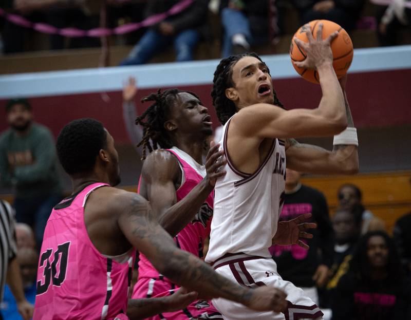 Kankakee's Lincoln Williams, right, makes a drive at the net as Rich Township's Taijon Eaton, center, and Jamson Coulter, left, guard in a game on Friday, February 6, 2026.