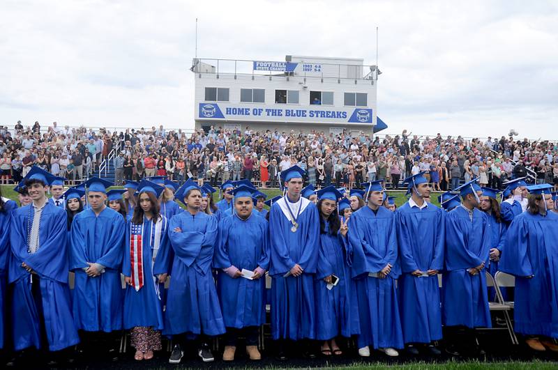 Graduates stand as they wait for the rest of their classmates to take their seats Sunday, May 15, 2022, during the Woodstock High School graduation ceremony in Woodstock.