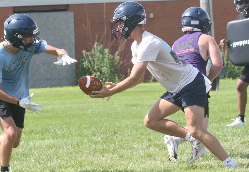 Bureau Valley quarterback Brandon Carrington, hands offa pass during training camp on Thursday, July 24, 2025 in Manilus.
