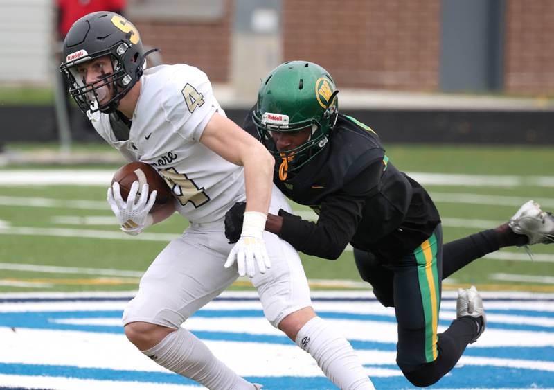 Sycamore's Aidan Wyzard picks up a few extra yards as Westinghouse's Elijah Carter tries to bring him down Saturday, Nov. 9, 2024 during their Class 5A second-round playoff game at Knute Rockne Stadium in Chicago.