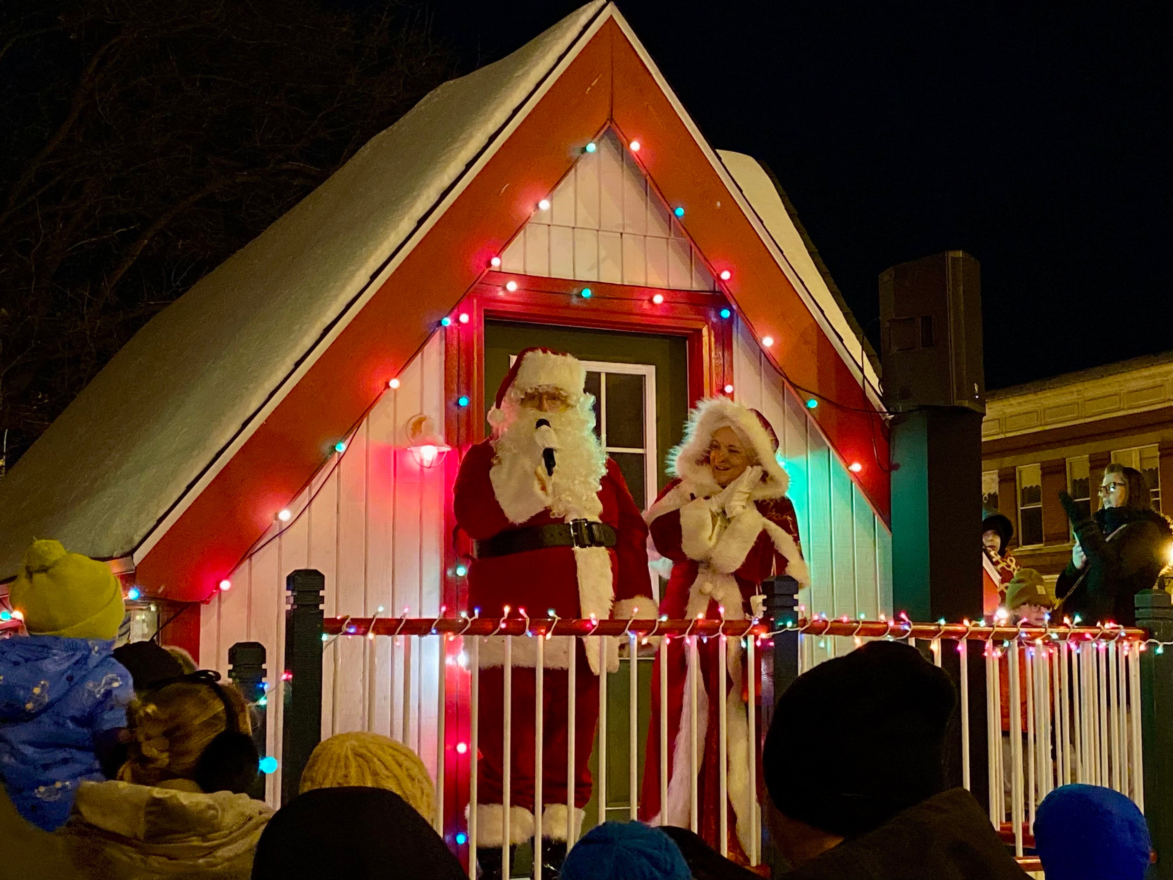 Santa Claus and Mrs. Claus stand outside their house in front of the DeKalb County Courthouse in downtown Sycamore on Friday, Dec. 5, 2025, for the annual Walk with Santa and lighting of the holiday tree.