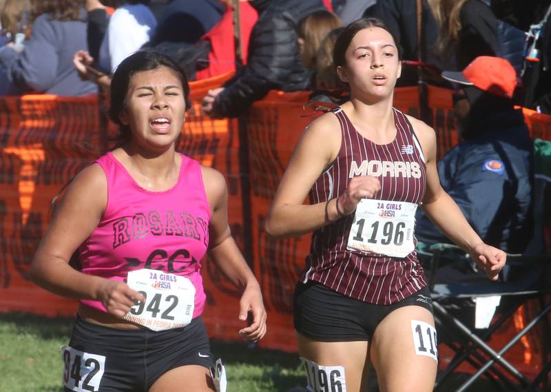 Aurora Rosary Kayla Garcia and Morris's Zara Lugo compete in the Class 2A State Cross Country race on Saturday, Nov. 4, 2023 at Detweiller Park in Peoria.