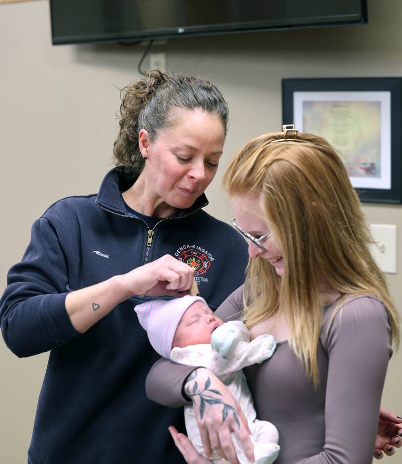 Genoa-Kingston firefighter paramedic Alicia Dimova gets a better look at a napping Eleanor Lee Altepeter-Knotts, and her mom Sammie Altepeter from Kingston Thursday, Nov. 2, 2023, as the baby and her family visit the Genoa-Kingston Fire Department in Genoa. Dimova and the rest of the ambulance crew delivered the baby in the ambulance along the side of the road Sept. 29 when they realized they weren’t going to make it to the hospital in time.