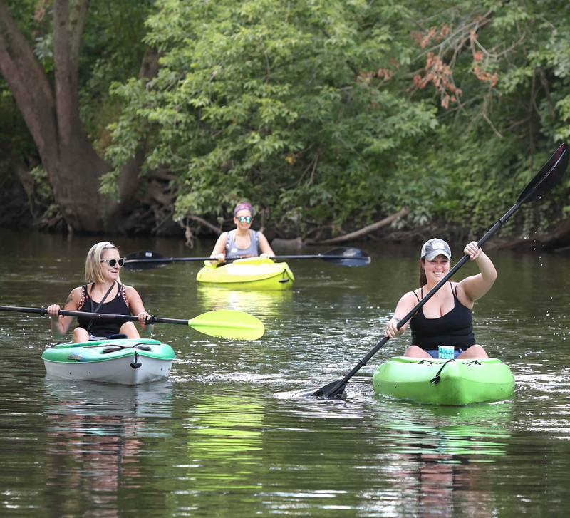 Carla Biesiadecki, (left) from Sycamore, Blair Montoya-Wilkinson, from Sycamore, and Danielle Thibault, (right) from Sycamore, paddle downstream in the Kishwaukee River Sunday, July 31, 2022, near David Carrol Memorial Citizens Park in Genoa.