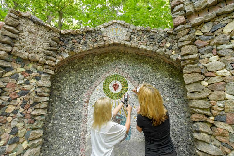 Volunteer Valerie Taylor and Chris Alimenti work on restoring the Geneva Grotto on Thursday, June 15, 2023.