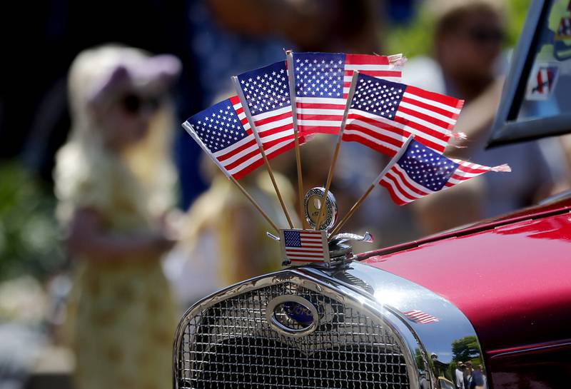 American Flags fly on the hood of a car during the Woodstock VFW Post 5040 City Square Memorial Day Ceremony and Parade Monday, May 29, 2023, in Woodstock.