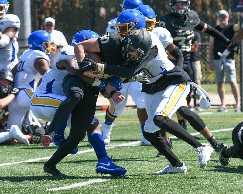 Sycamore Burke Gautcher (10) tries to gain more yards while being wrapped up by a few Simeon players in the second quarter on Saturday Sep. 2, 2023, held at Gately Stadium in Chicago.