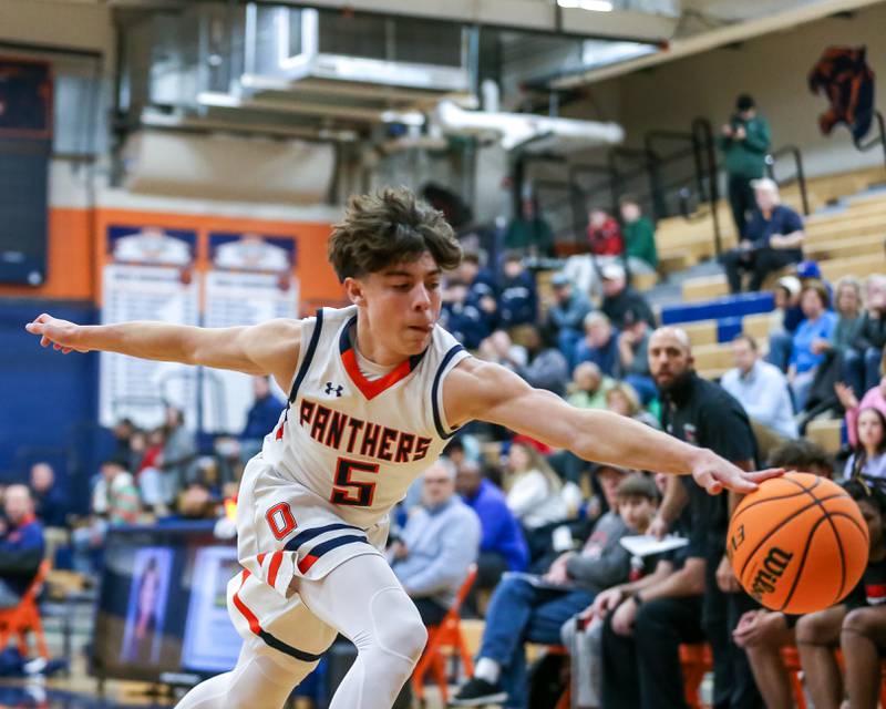 Oswego's Mariano Velasco (5) reaches for a loose ball during their basketball game between Yorkville at Oswego, Tuesday Dec 10, 2024 in Oswego.