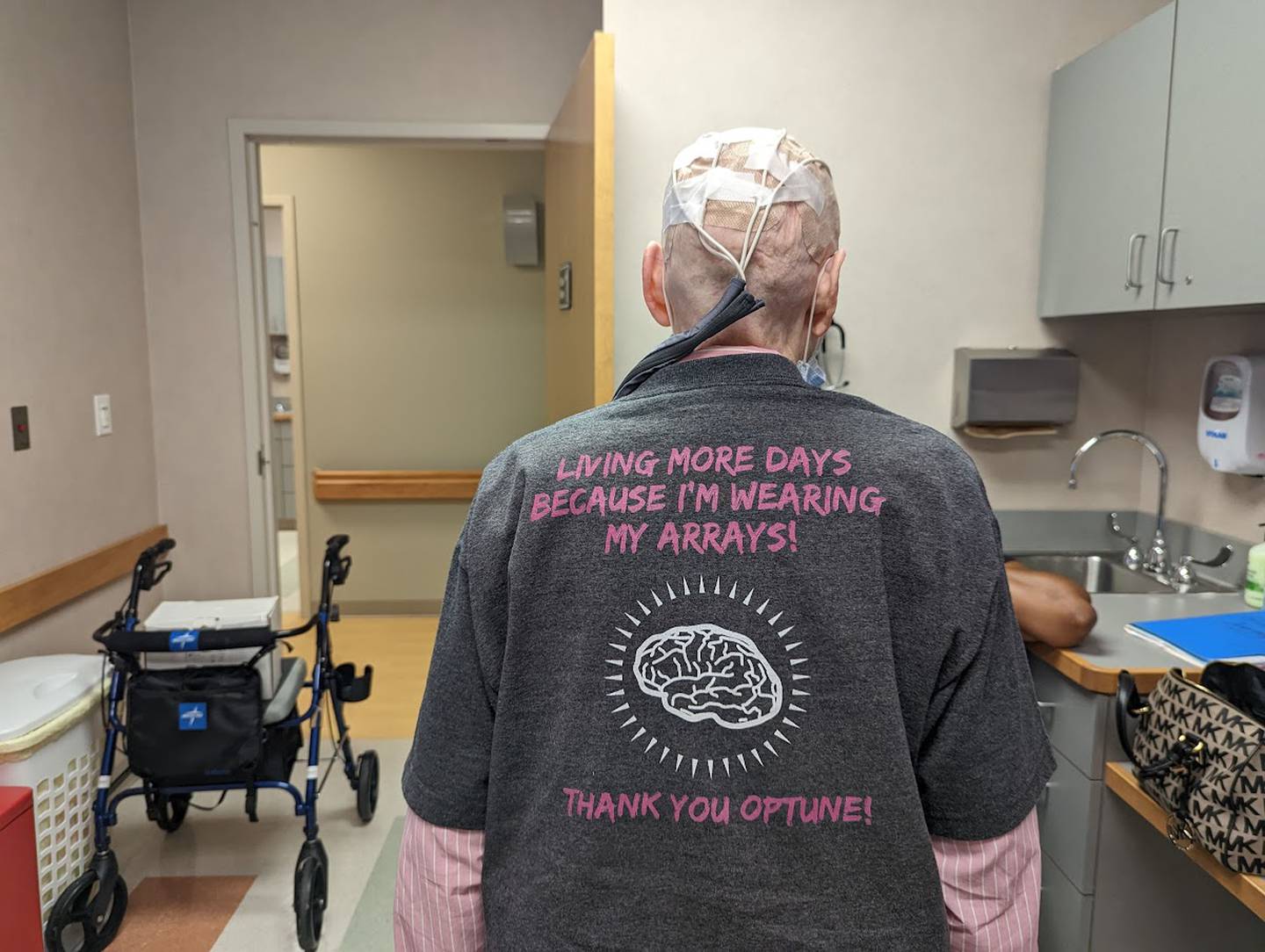 Libby Hall, 75, of Joliet, shows off her shirt on Friday, Sept. 16, 2022, at Joliet Oncology-Hematology Associates. Hall was diagnosed with glioblastoma multiform, an aggressive brain cancer, in 2020 and is currently wearing a device called Optune, which delivers an electrical field into the cancer cells in her brain.