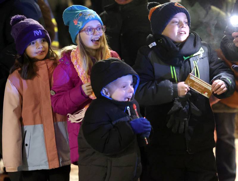 Kids look on in wonder as Santa Claus approaches the Egyptian Theatre aboard his truck Thursday, Dec. 4, 2025, during the annual Lights on Lincoln and Santa Comes to Town event hosted by the DeKalb Chamber of Commerce.