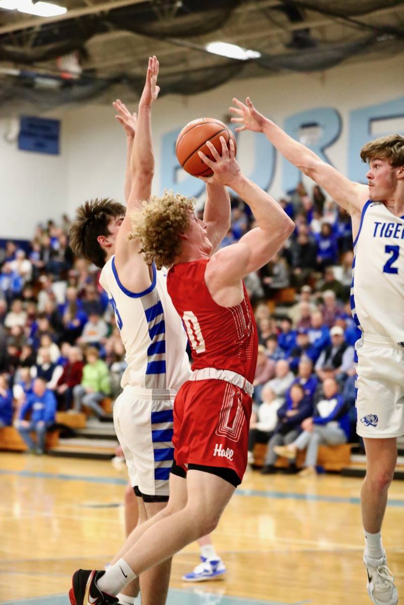 Hall's Mac Resetich navigats to the  basket against Princeton's Teegan Davis and Noah LaPorte in the first half of Thursday's regional semifinals at the Storm Cellar. Princeton won 88-43.