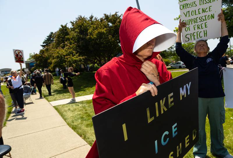 Jenny Golden wears a handmaids outfit during a “No Kings Day” Protest against President Donald Trump’s policies along South Randall Road in Geneva on Saturday, June 14, 2025.