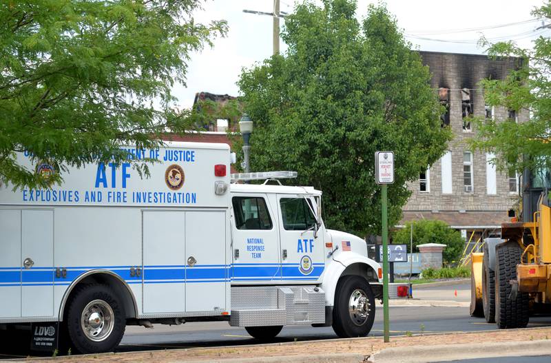 A large ATF vehicle sits in the municipal lot across from the charred apartment building at 406 East Third Street in Sterling that was destroyed by an early morning fire on Friday. Lettering on the vehicle says "Explosives and Fire Investigation" and "National Response Team".