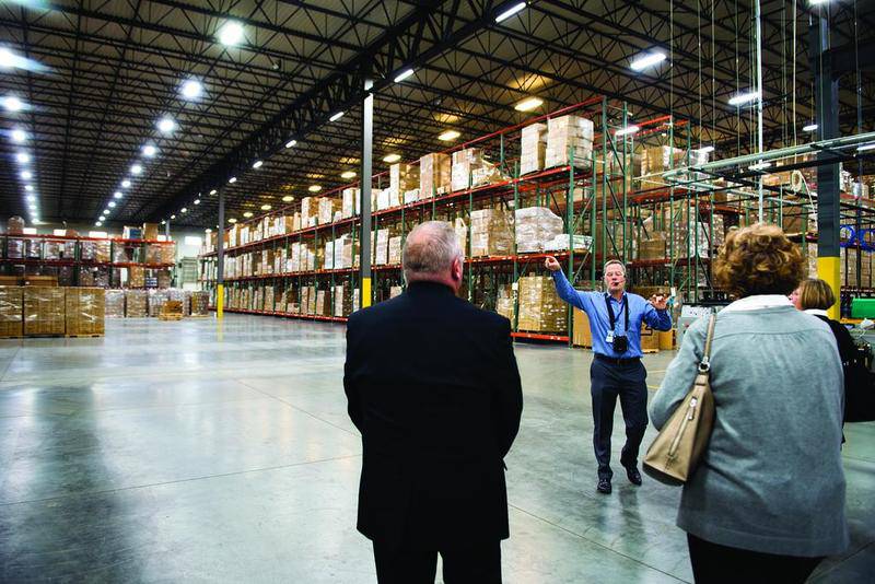 Steven Yde of Wahl Clipper leads a tour group through one of the company's warehouses Monday. Walmart, the company's largest customer, brought its "Made in America" movement to Sterling on Monday, drawing a large group of politicians, local leaders and employees of both companies.