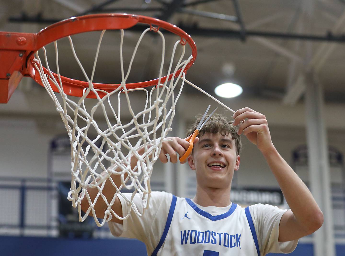 Woodstock's Max Beard cuts down the net after Woodstock defeated Woodstock North to win the Kishwaukee River Conference boys basketball championship on Wednesday, February. 18, 2026, at Woodstock High School.