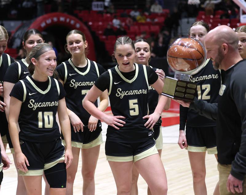 The Sycamore girls basketball team receive the trophy after beating DeKalb 38-26 Friday, Jan. 30, 2026, in the FNBO Challenge at the Convocation Center at Northern Illinois University in DeKalb.
