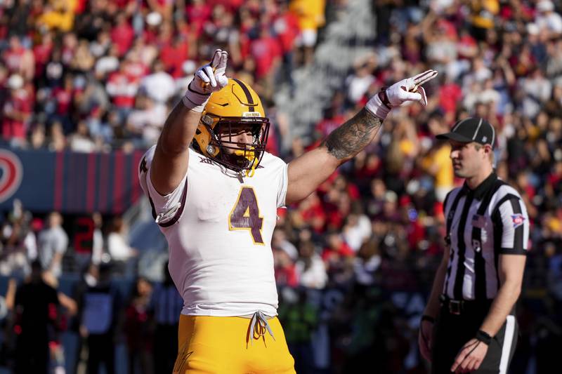 Arizona State running back Cam Skattebo (4) celebrates scoring a touchdown during the first half of an NCAA college football game against Arizona, Saturday, Nov. 30, 2024, in Tucson, Ariz. (AP Photo/Samantha Chow)