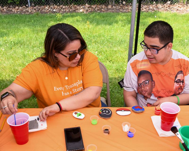 Georgina Peña (left) and son Andy Valtierra, of Little Rock Arkansas, paint rocks on Saturday, June 7, 2025, during the Ezra Hill Jr. Memorial Foundation’s 5th annual rock painting event held at Tyler Elementary School in DeKalb. The foundation was created to memorialize the late DeKalb boy, shot and killed in 2019. Ezra donated his heart to Andy.