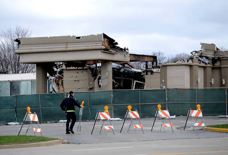 A firefighter puts a barricade back up to close off the parking lot of the D’Andrea Banquets and Conference Center, at 4419 Route 14 in Crystal Lake, on Tuesday, April 19, 2022. A fire Saturday left parts of the roof collapsed and the building a total loss, fire officials said.
