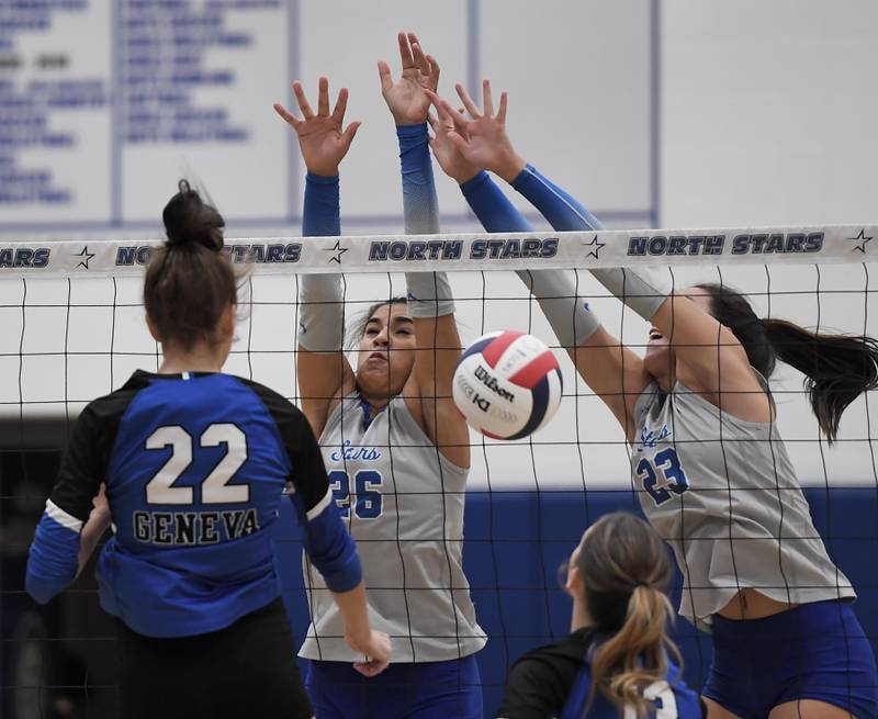 St. Charles North’s Sidney Wright, left, and Haley Burgdorf block a shot by Geneva’s Charlotte Potvin in a girls volleyball match in St. Charles in Tuesday, October 17, 2023.