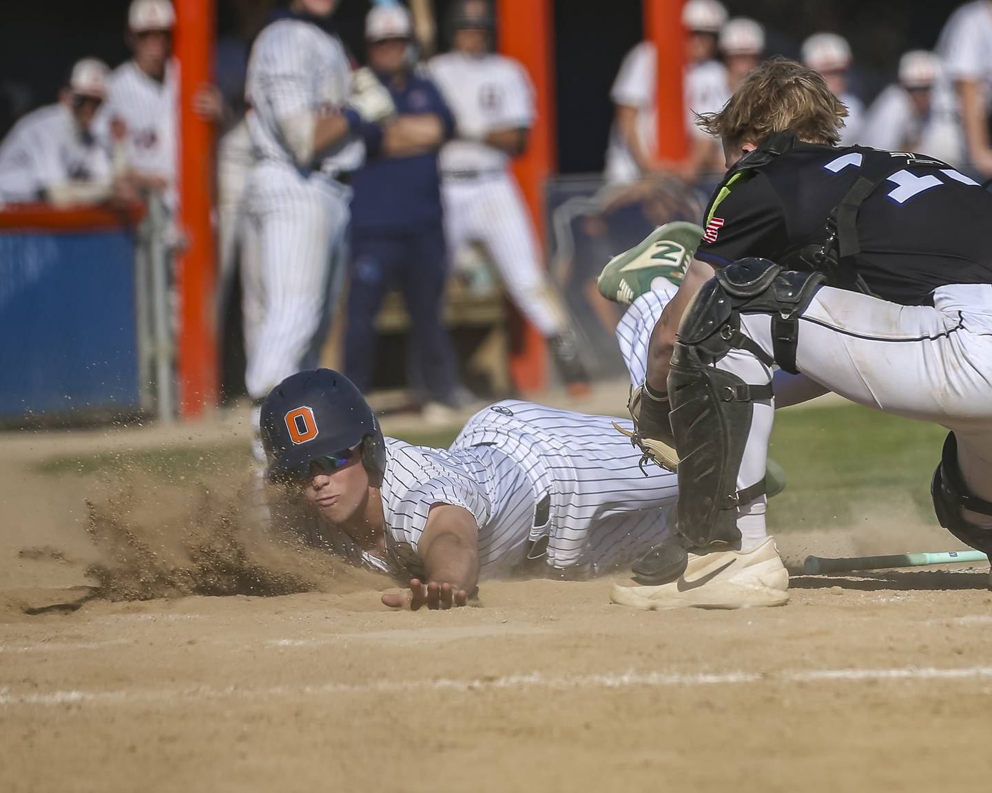 Oswego's Graham Schwab (2) slides safely into home during baseball game Oswego East at Oswego.  May 14, 2026 in Oswego.