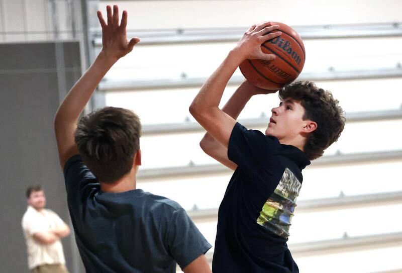 Caleb Krueger, (left) 13, guards his brother Cole, 15, Wednesday, Aug. 28, 2024, as they play basketball at their house in Genoa. The pair recently earned Guinness World Record record for the most basketball passes in a minute for a pair under 16 and are planning an attempt at breaking the world record for the most three pointers in a minute by a duo.