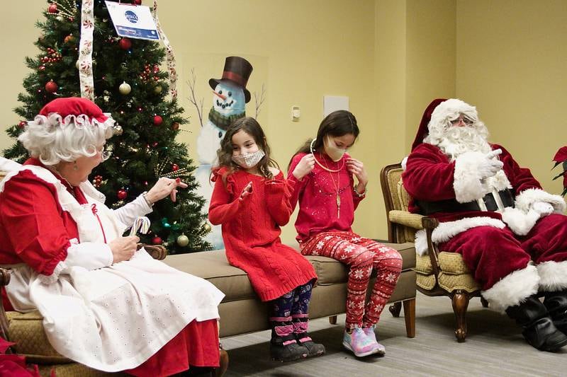 Abrianna and Jaidyn Liszka (center left and right) came from Sugar Grove to visit with Santa and Mrs. Claus at Montgomery's Village Hall during the tree lighting celebration Dec. 5.