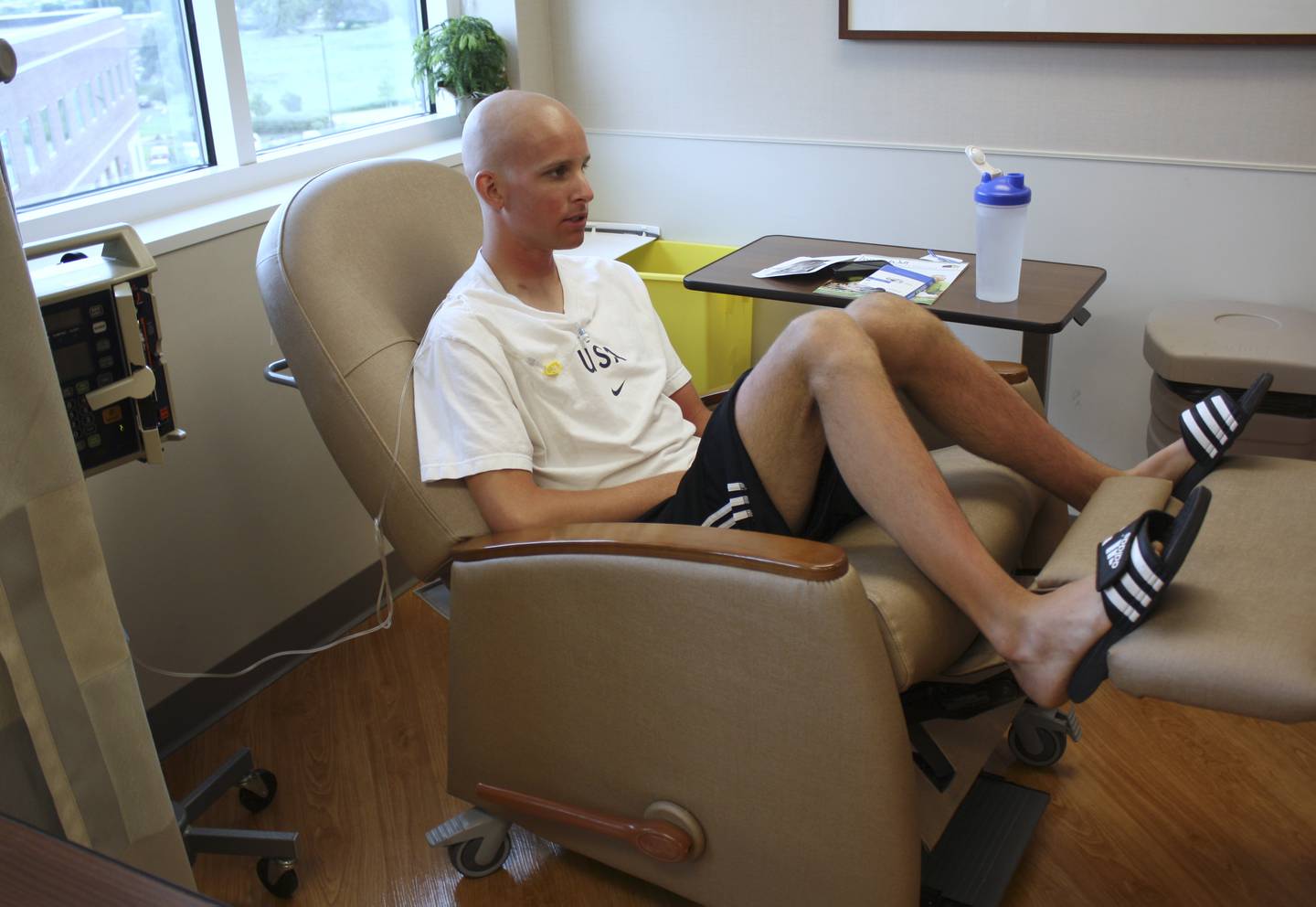In this photo taken June 27, 2011, Kevin McDowell sits for a chemotherapy treatment in Geneva, Ill. McDowell, an elite triathlete from suburban Chicago, was diagnosed this spring with Hodgkin's lymphoma, causing him to have to withdraw from competing this September in the Junior World Championships in China, where he was a favorite to win. His friend and teammate Lukas Verzbicas, who has committed to running at the University of Oregon, made the decision to compete in McDowell's place to honor his friend.