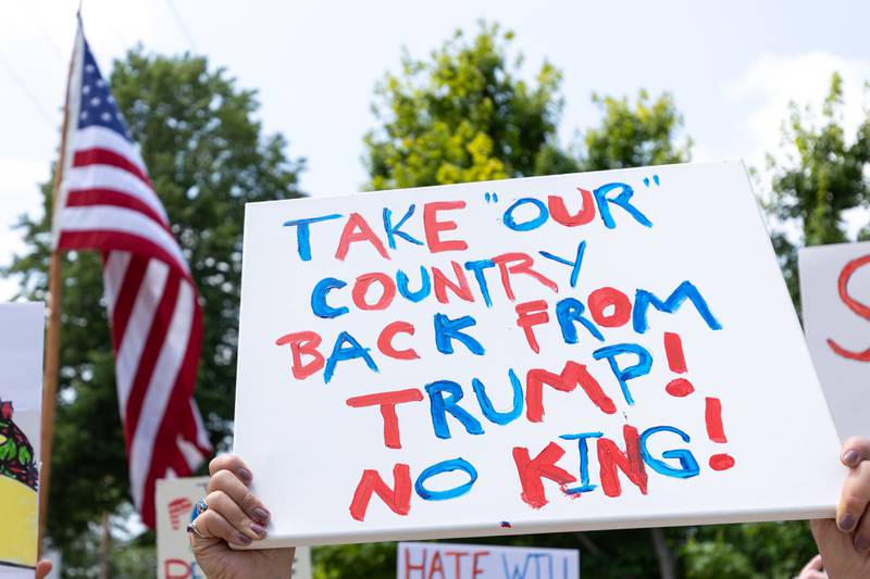 Sign that reads “Take ‘Our’ Country Back From Trump! No King!” is held at the “No Kings” protest on Saturday, June 14, 2025 at Rotary Park in Princeton.
