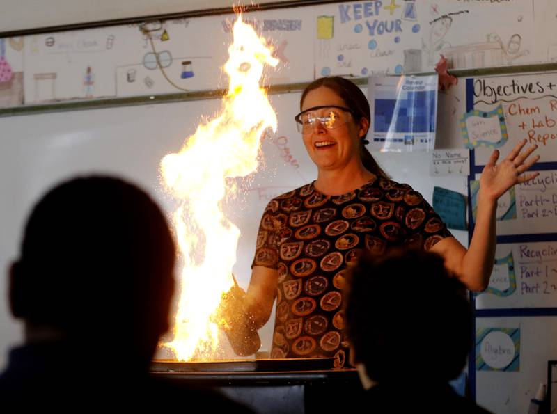 Teacher Ally Egert performs an experiment with coffee creamer and fire  for her sixth-grade students Monday, May 1, 2023, at Montini Catholic School in McHenry.