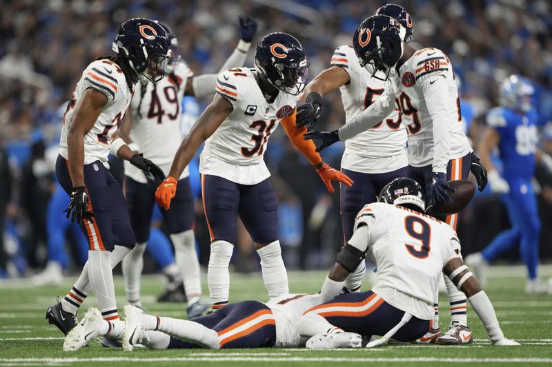 Chicago Bears players check on teammate cornerback Jaylon Johnson (1) after he was injured during the first half of an NFL football game in Detroit, Sunday, Sept. 14, 2025. (AP Photo/Ryan Sun)