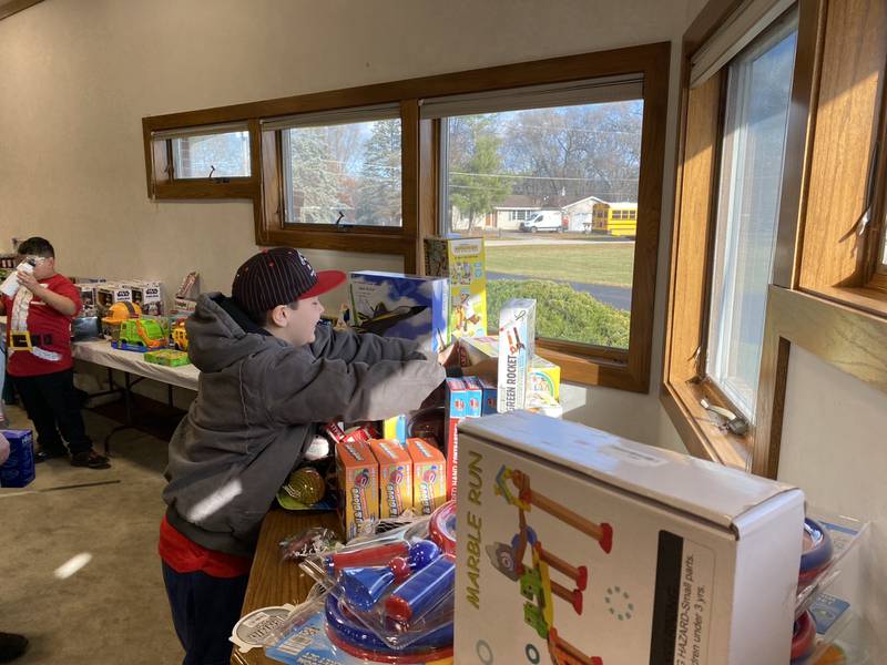 Matthew T. reaches for a toy at the Grundy County Heroes and Helpers Shop with a Local Hero event on Saturday morning.