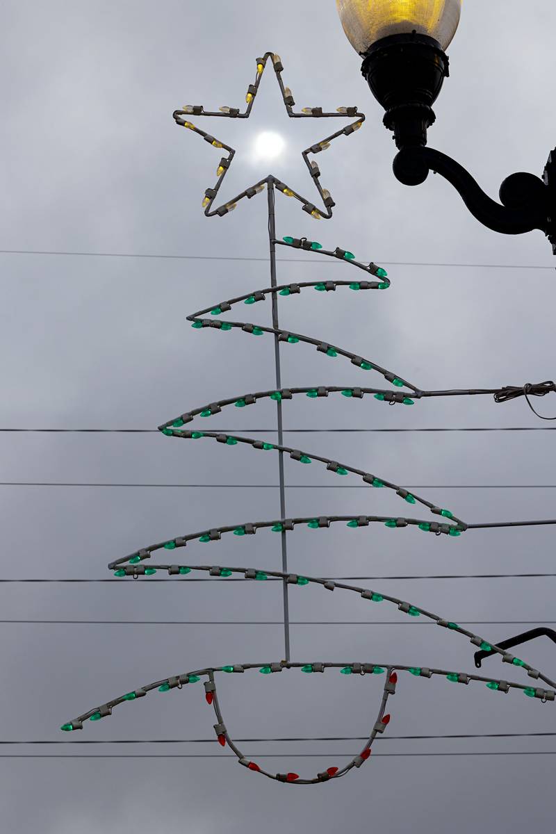 A dim sun shines through the Christmas decorations on the Galena avenue bridge in Dixon. Snow started to fly in the early hours of Tuesday.