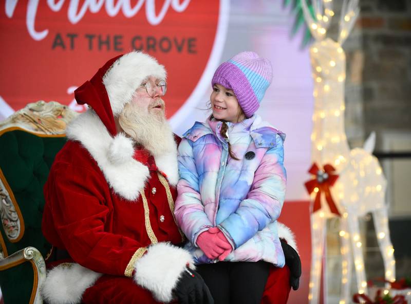 Charlotte Gifford, 8, of Bourbonnais, tells Santa her wish list on Saturday during the Miracle at The Grove event.