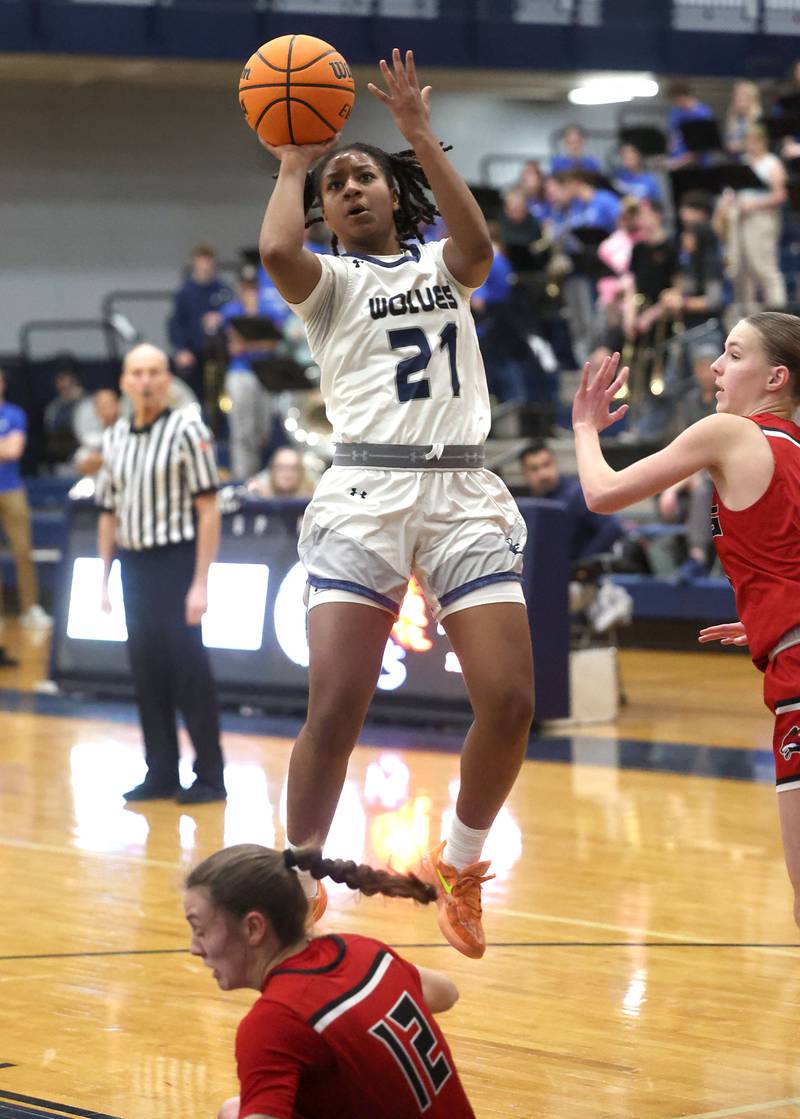 Oswego East's Desiree Merritt shoots over a fallen Yorkville's Elaine Gussman during their game Tuesday, Feb. 11, 2025, at Oswego East High School.