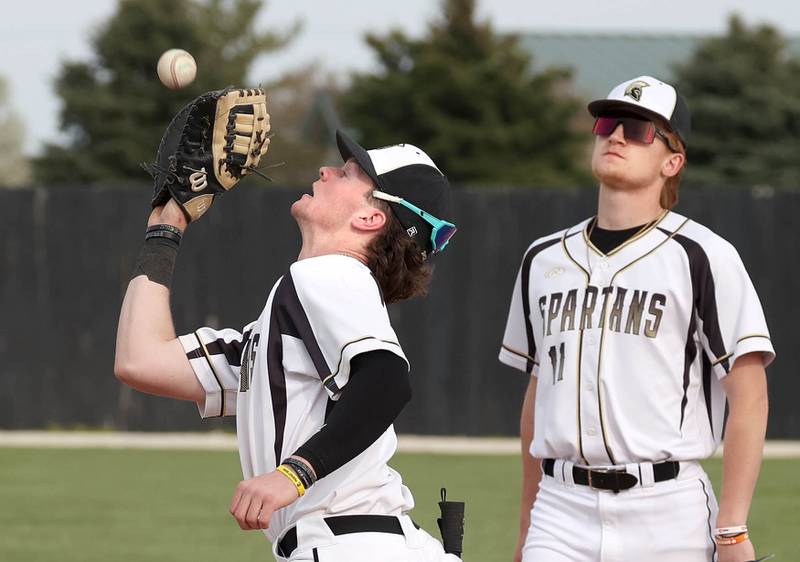 Sycamore's Davis Collie catches a popup in front of Teague Hallahan during their game against Kaneland Monday, April 22, 2024, at the Sycamore Community Sports Complex.