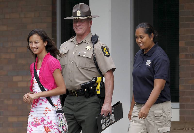 Deputy Khalia Satkiewicz (right), her husband, Illinois State Police Master Sgt. Robert Satkiewicz, and daughter, Sierra, 13, leave the McHenry County Government Center on Thursday in Woodstock after Scott Peters was sentenced to 135 years in prison.