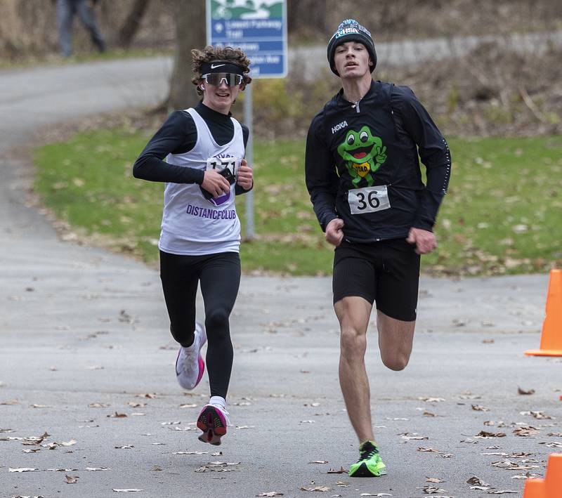 Bentlee Lawrence (left) and Dean Geiger race to the finish Thursday, Nov. 28, 2024, during St. Anne’s Turkey Trot 5K. Geiger edged out Lawrence for third place.