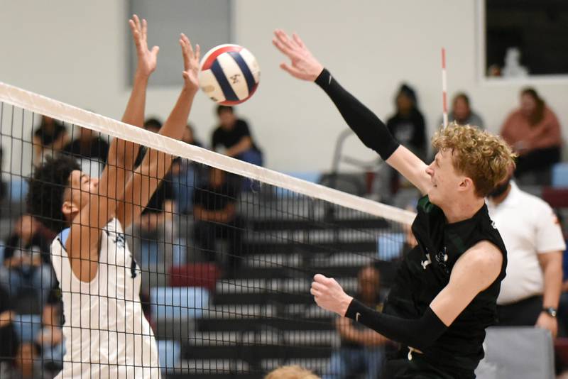 Bishop McNamara's Richie Darr, right, looks to send a hit past Kankakee's Joshua Anderson during a game at Kankakee Tuesday, March 31, 2026.