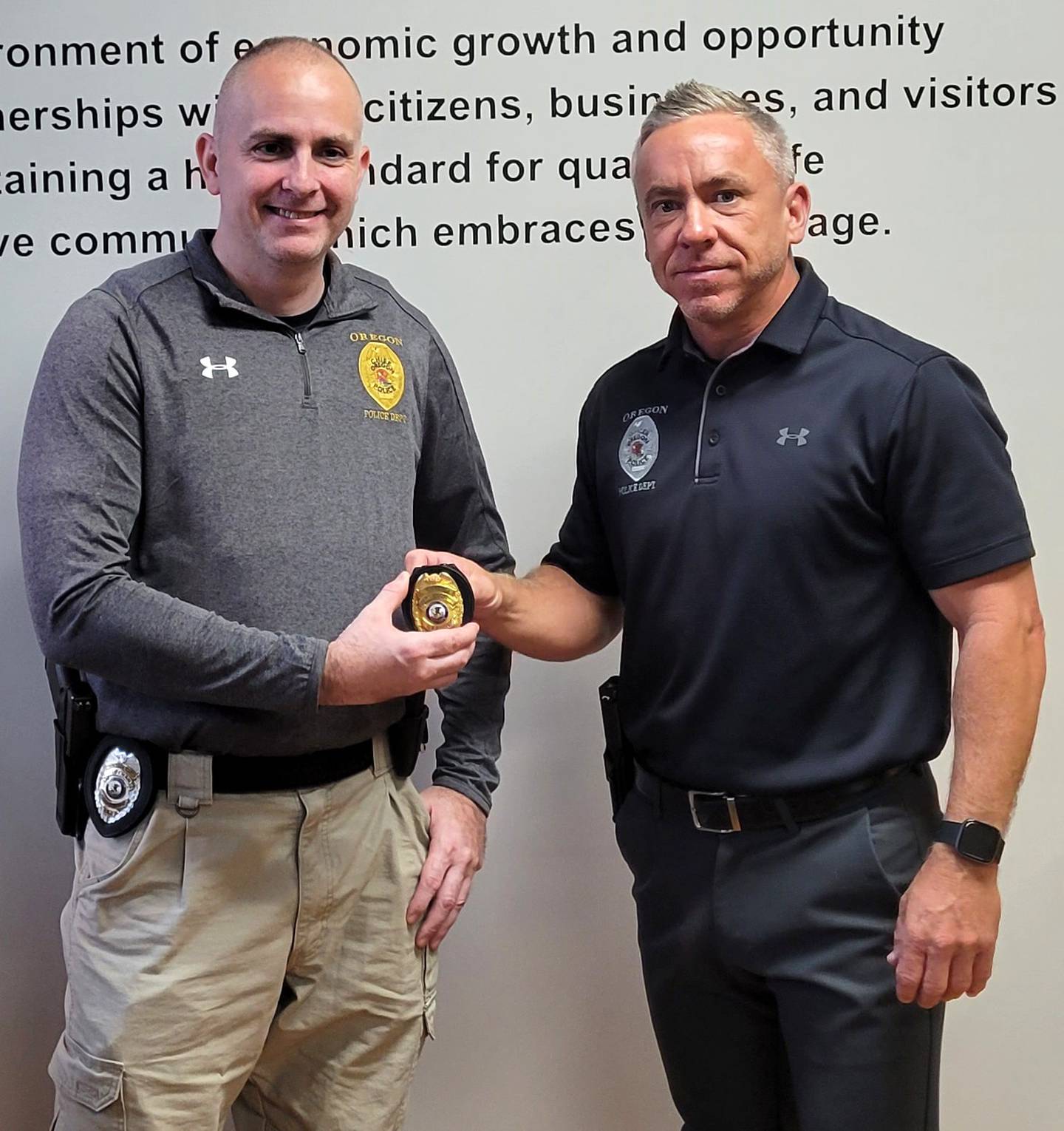 Oregon Police Chief Shawn Melville, right, hands the chief badge to incoming police chief, Joseph Brooks. Brooks was sworn in on Sept. 27 and will become chief effective Oct. 3.