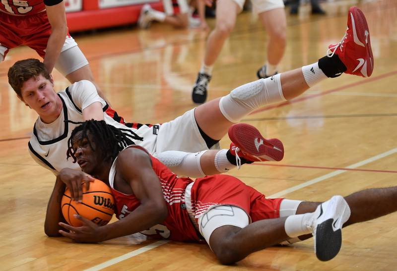Benet’s Colin Stack (top) tangles on the floor with Marist’s Marquise Vance during a game on Friday, Dec. 13, 2024 at Benet Academy in Lisle.