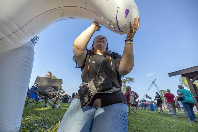 Hailey Druien of Milledgeville signs an inflatable unicorn  Saturday, June 14, 2025, at Sauk Valley Pride Fest in Dixon.