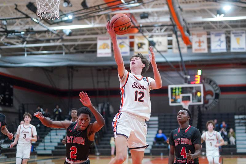 St. Charles East's Sam Tisch (12) drives to the basket on a fast break against East Aurora during the 64th annual Ron Johnson Thanksgiving Basketball Tournament at St. Charles East High School on Monday, Nov 20, 2023.