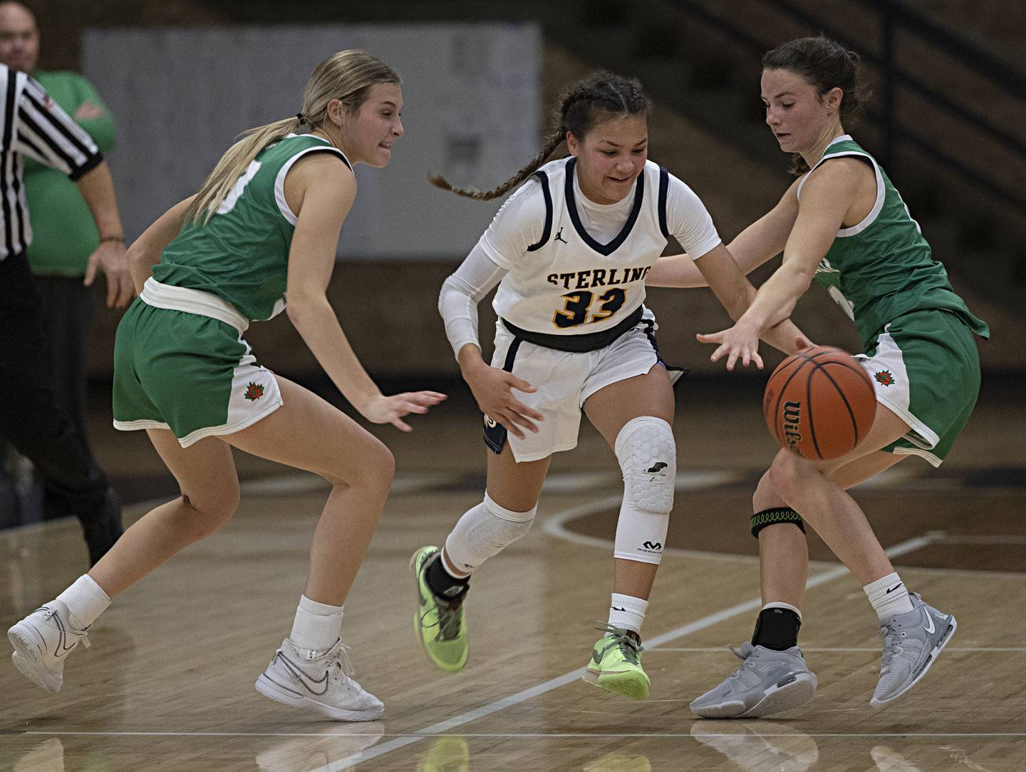 Sterling’s Joslynn James dribbles through Geneseo’s Kendall Ellerbrock (left) and Mia Kelly Thursday, Dec. 7, 2023 at Sterling High School.