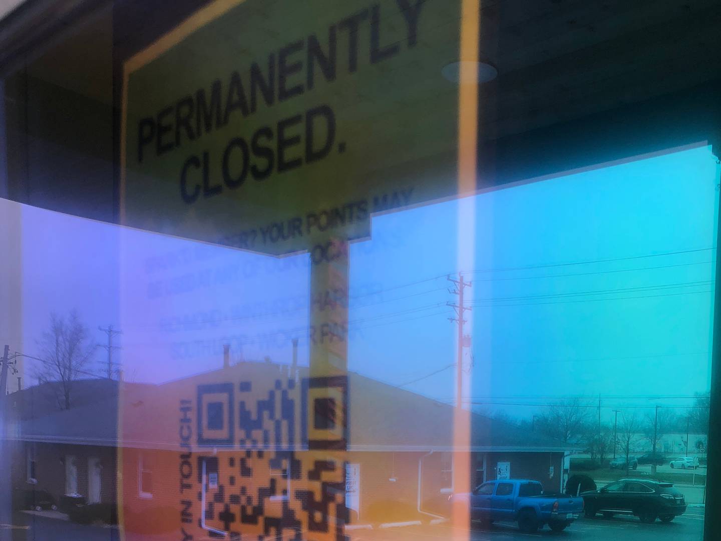 A sign announcing the Spark'd Dispensary in Crystal Lake has closed, seen here on Sunday, Dec. 29, 2024, is hard to read through an iridescent film on the door at  330 N. Route 31.
